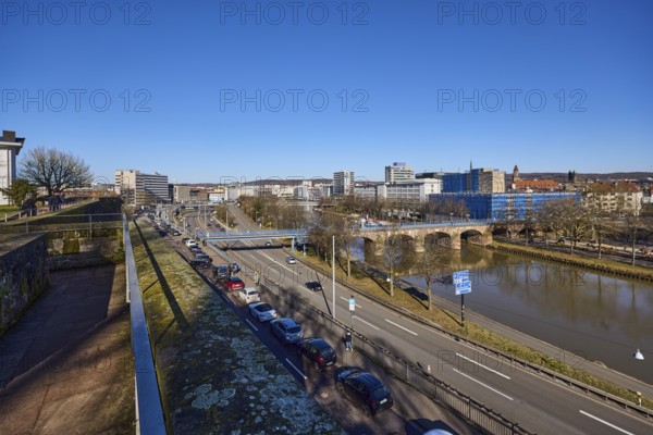 Long shot, castle fortification, river Saar, streets, cars, pedestrian bridge, trees, parking strip with vehicles, river bank, footpath and cycle path, reflections on the water surface, bird's eye view, blue sky, cloudless, Old Bridge, Franz-Josef-Röder-Straße, motorway A620, Saarbrücken, state capital, regional association Saarbrücken, Saarland, Germany, Europe
