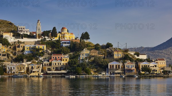 Hilltop town by the water with church and Mediterranean architecture, Symi Town, Symi, Dodecanese, Greek Islands, Greece, Europe