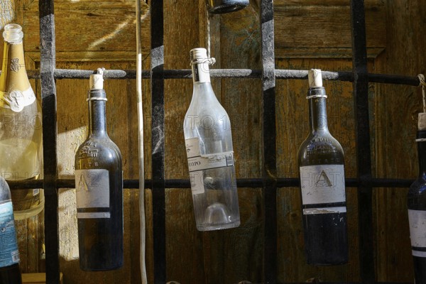 Various bottles hanging from a black metal grid, Symi Town, Symi, Dodecanese, Greek Islands, Greece, Europe