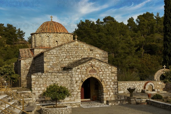Historic stone church under a blue sky surrounded by trees, Thari Monastery, Moni Thari, near Gadouras Reservoir, lonely mountain region, Rhodes, Dodecanese, Greek Islands, Greece, Europe