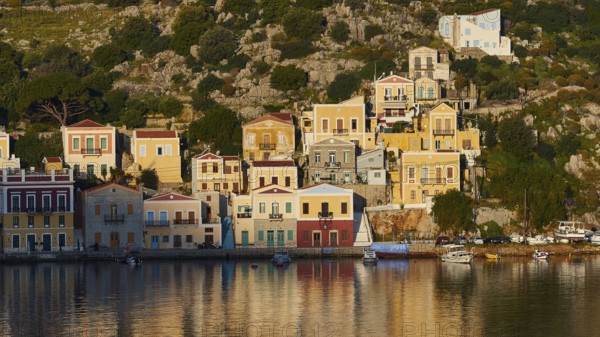 Colourful buildings along the water with some boats on the shore, Mediterranean scenery, Symi town, Symi, Dodecanese, Greek Islands, Greece, Europe
