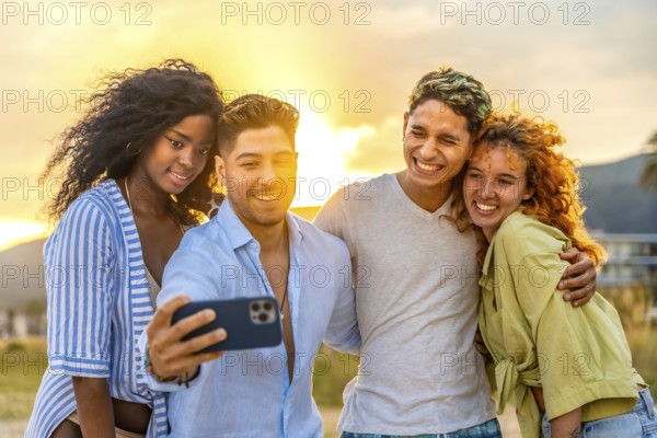 Four cheerful young friends enjoying a sunset beach selfie, capturing joyful moments filled with laughter and togetherness during summer vacation