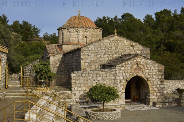 Older Byzantine church with a round tiled roof and a cross on the dome, surrounded by trees and nature, Thari Monastery, Moni Thari, near Gadouras Reservoir, lonely mountain region, Rhodes, Dodecanese, Greek Islands, Greece, Europe
