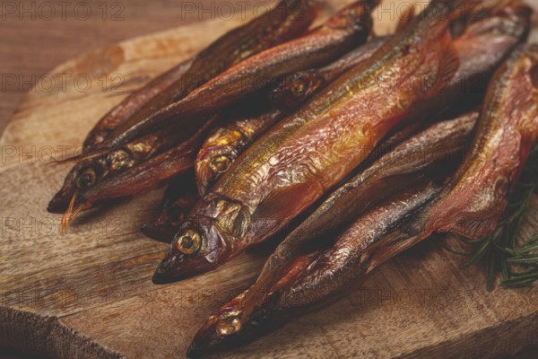 Cold smoked capelin, on a wooden chopping board, no people