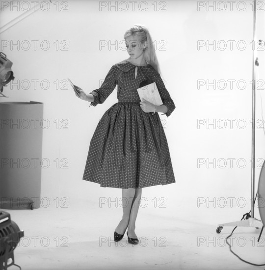 1950s fashion. A young woman in a typical 1950s dress. A wide skirt dress with a 50s patterened fabric. Sweden 1959. Kristoffersson ref CO93-2