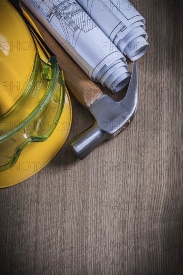 Claw hammer safety glasses rolled blueprints and building helmet