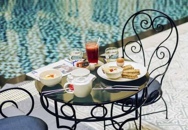 Gourmet continental breakfast table set at luxury hotel poolside