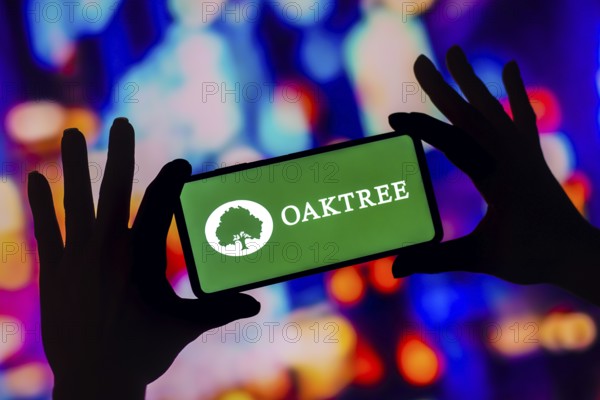 In this photo illustration, the Oaktree Capital Management logo is displayed on a smartphone screen