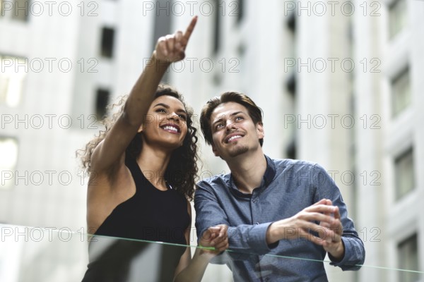 Happy international couple have a conversation in city. Mixed-race woman and caucasian man