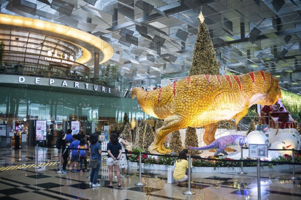08.12.2020, Singapore, Republic of Singapore, Asia, dinosaurs, a sleigh and a Christmas tree serve as Christmas decorations and photo backdrop in Dino Wanderland for visitors and air travellers in the departure hall in Terminal 3 of Changi International Airport amid the global coronavirus (Covid-19) pandemic, Asia