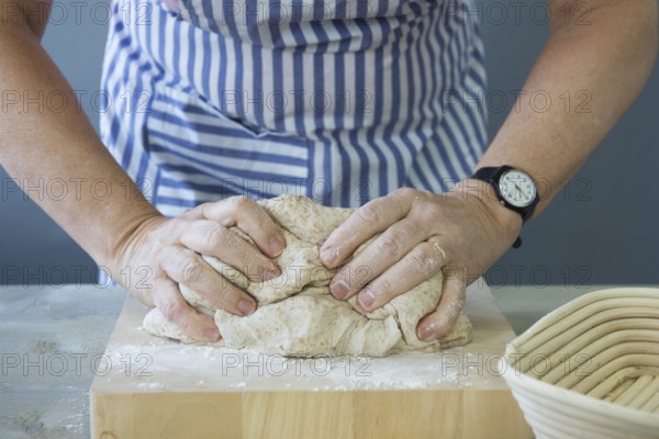 Female hands kneading bread dough