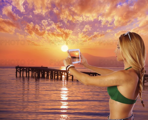 Blond tourist girl taking photos of Mallorca Alcudia beach sunset photomount
