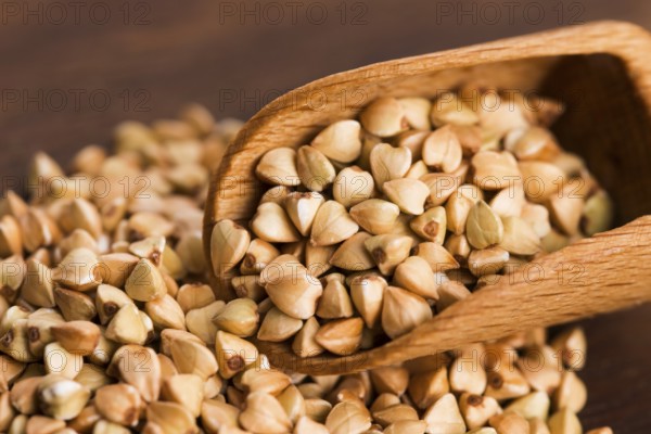 Buckwheat with a spoon on a wooden board background