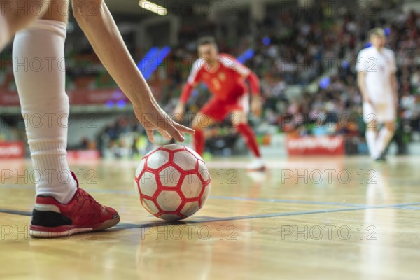 Close up of the futsal ball in the corner and player's leg