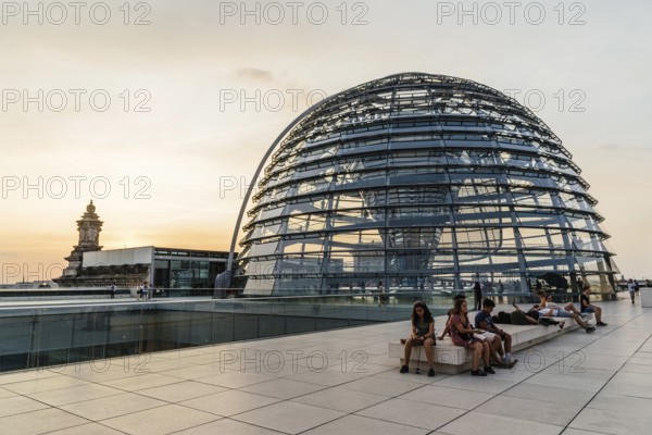 Berlin, Germany, July 28, 2019: View of the dome of Reichstag building, seat of the German Parliament. People enjoying the views at sunset, Europe