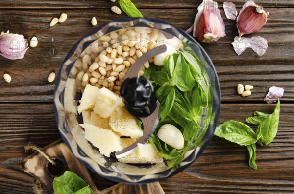 Ingredients for italian national traditional genovese pesto sauce in food processor bowl. Flat lay view