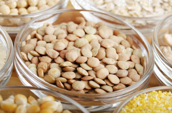Lentils closeup in glass bowl on wooden kitchen table, non-perishable, long shelf life food concept