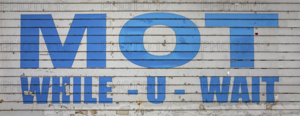 A Grungy Old MOT While You Wait Sign In The UK