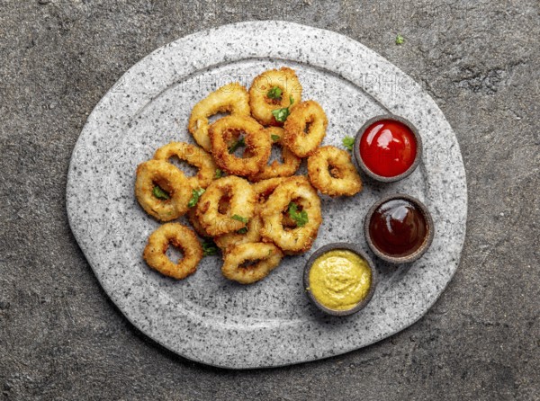 Food, Food, Fried squids rings on gray stone plate with sauces. Gray concrete background