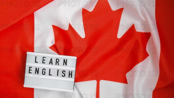 The National Flag of Canada. Lightbox with text LEARN ENGLISH Canadian Flag or the Maple Leaf. Patriotism. International relations concept. Independence day. Immigration