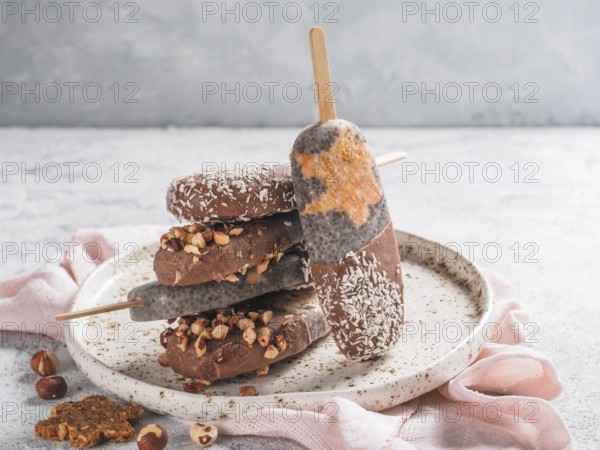 Chia popsicle with raw carrot cake and chocolate on gray background. Healthy recipe and idea homemade vegan popsicle ice cream. Easter dessert idea. Copy space for text