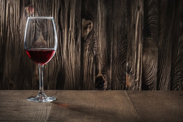 Copyspace view wineglass with red wine on vintage wooden background