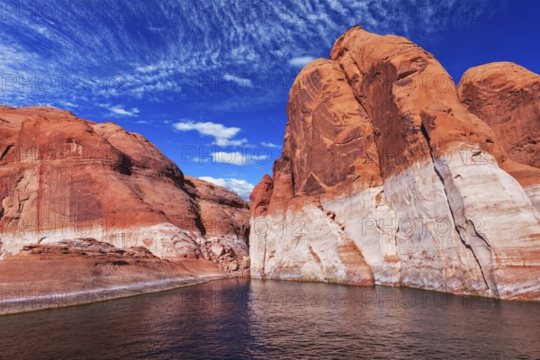 Lake Powell is surrounded by magnificent red hills. Walk on the boat at sunset. Scenic huge artificial water basin of the Colorado River, USA, North America