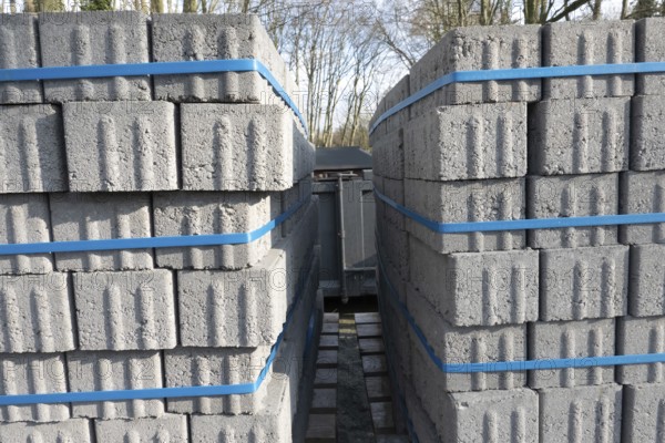 Concrete bricks, secured with blue straps, are being transported on a truck, ready for construction or landscaping projects, Bottrop, NRW, Germany, Europe
