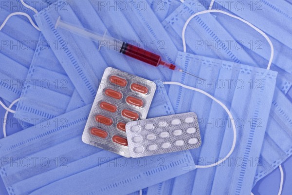 Protective medical mask, pills, syringe on blue background, corona virus protection, Concept of a prevention and treatment coronavirus, covid19 protection concept. Global pandemic
