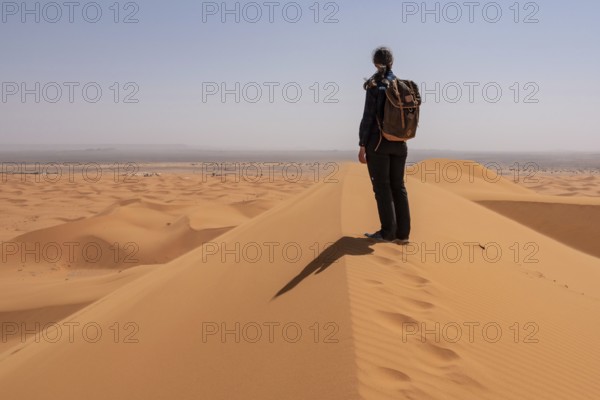 Hiking up the Great Dune of Merzouga in the Erg Chebbi desert, Moroccan Sahara desert