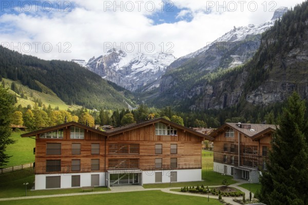 Wooden chalet in Kandersteg village, Canton Bern, Switzerland, Europe, Autumn trees and mountains panorama, Europe