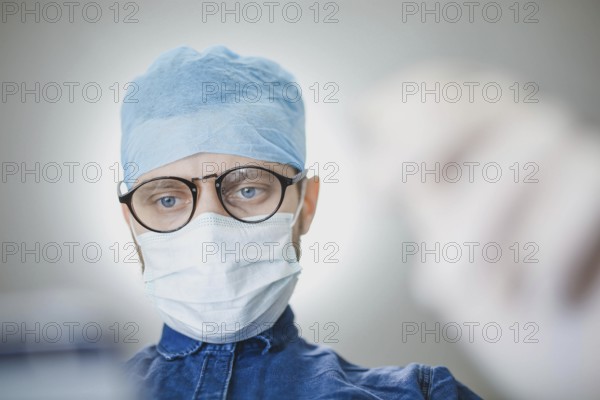 Medical professional in surgical attire concentrating in a hospital setting