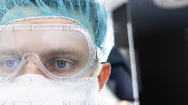 Close-up of a doctor wearing transparent goggles and a face mask