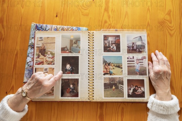 Top view of a senior caucasian woman looking at an old photo album themes of memories nostalgia photos retired