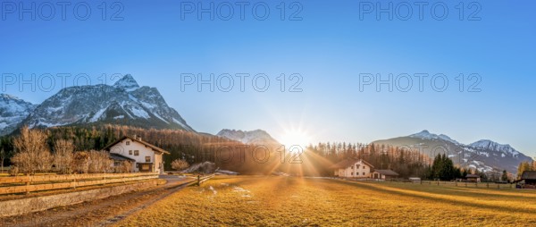 Beautiful mountain landscape with a small village, called Ehrwald, located at the foot of the Austrian Alps, under a clear blue sky and a gorgeous sun