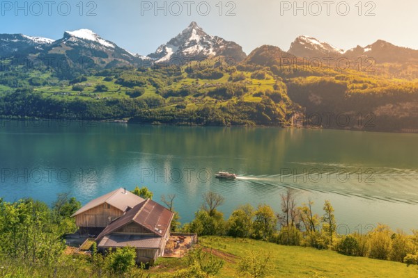 Lovely vacation destination in the Swiss Alps, around the Walensee lake. A spring scenery with mountains, lake, meadows and warm sun