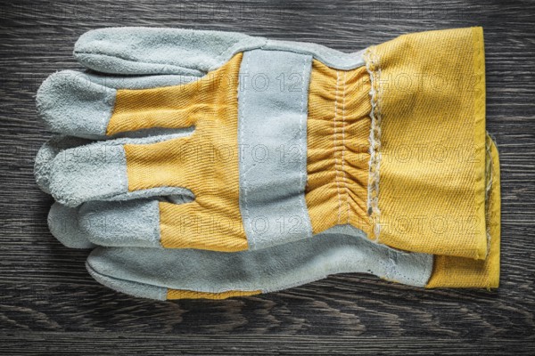Protective gloves on wooden board top view
