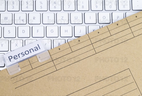 The photo shows a white keyboard with a personnel file