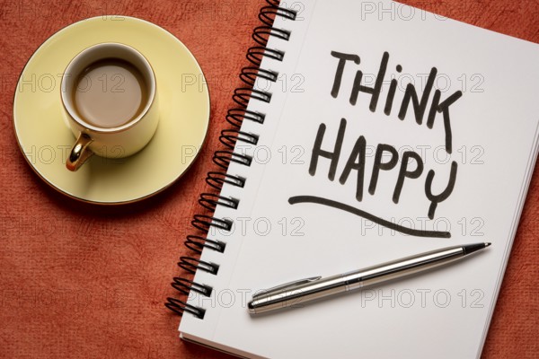 Think happy inspirational handwriting in a sketchbook with a cup of coffee, personal development, mindset, happiness and positivity concept