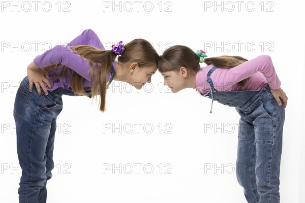 Quarrel two girls standing leaning their foreheads against to each other