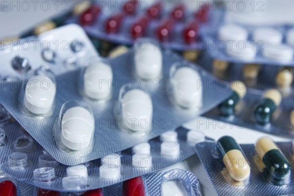 Close-up view of mixed blister packs containing white and colored capsules