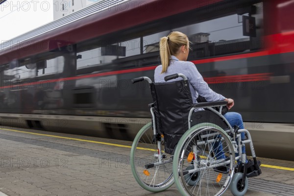 A young woman sits in a wheelchair at a railway station in Austria