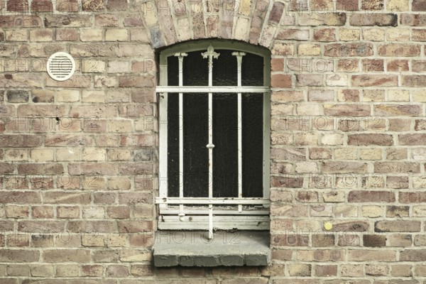 Barred cellar window in a brick wall