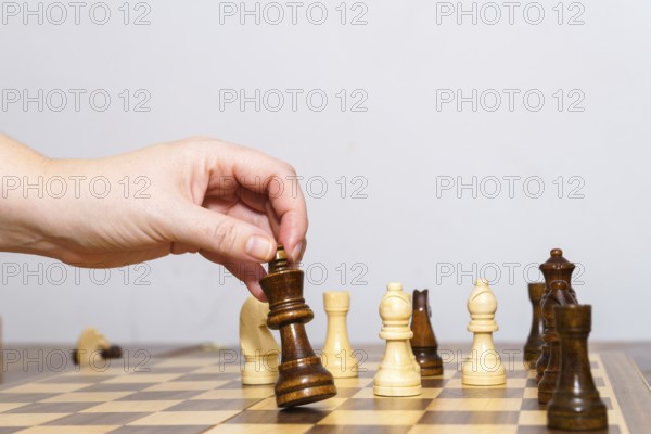 Close-up of a woman's hands playing chess with a white background and copy space