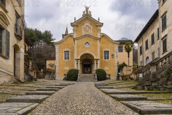 Orta San Giulio, Italy, 13 March, 2023: steep cobblestone street leading to the historic Penotti Ubertini Palace in Orta San Giulio, Europe