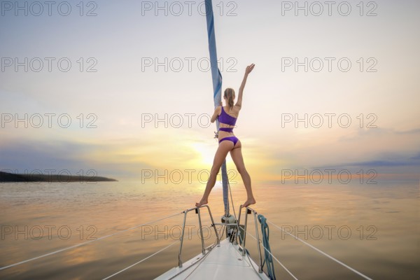 Girl sailing on the yacht on a meeting the sun. Girl waves her hand from the yacht. Romantic walk on the yacht. Traveling on a yacht