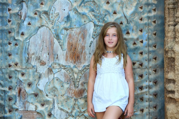 Kid girl tourist in Mediterranean old town door at Spain