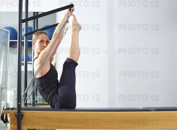 Pilates woman in reformer monki exercise at gym indoor