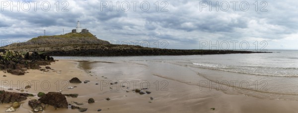 A panorama view of the Mumbles headland with the historic lighthouse in Swansea Bay