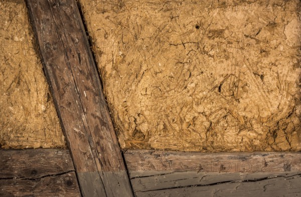 Clay house wall, with details on the wooden beams and the mixture of mud and straw, perfect as background